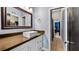 Bathroom showcasing a contemporary vanity, rectangle sink, framed mirror, and tile flooring leading to bedroom at 3943 W Campbell Rd, Lakeland, FL 33810