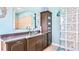 Bright bathroom with a glass bowl sink, granite countertops, a large mirror, and blue accents at 3943 W Campbell Rd, Lakeland, FL 33810