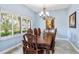 Formal dining room features a large wood table, chandelier, and window with a green outdoor view at 3943 W Campbell Rd, Lakeland, FL 33810