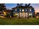 Elegant blue two-story home with a columned porch, complemented by a well-manicured lawn and vibrant landscaping at 3943 W Campbell Rd, Lakeland, FL 33810