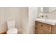 Small powder room with a wooden vanity and patterned wallpaper at 400 W Hazel St, Orlando, FL 32804