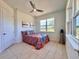 Bright bedroom with tiled floors, a ceiling fan, and a view of the backyard at 41289 County Road, 452, Leesburg, FL 34788