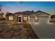 Two-story house with stone accents, three-car garage, and a large driveway at dusk at 41289 County Road, 452, Leesburg, FL 34788