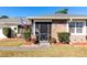 House exterior featuring a screened porch and landscaping at 425 Iowa Woods E Cir, Orlando, FL 32824