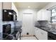 White kitchen with marble backsplash and black appliances at 425 Iowa Woods E Cir, Orlando, FL 32824