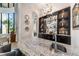 Elegant wet bar with granite countertop and glass shelving at 4326 Isabella Cir, Windermere, FL 34786