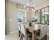 Dining area with light wood table, neutral decor, and stylish chandelier at 4418 Small Creek Rd, Kissimmee, FL 34744