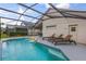 Enjoy this refreshing pool with a screened enclosure and lounge chairs at 4705 Pershoie Ln, Kissimmee, FL 34746