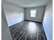 Simple bedroom with wood-look floors and a window at 5325 Curry Ford Rd # 101, Orlando, FL 32812