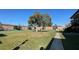 Apartment complex courtyard with grassy areas, walkways, and a tennis court at 5325 Curry Ford Rd # 101, Orlando, FL 32812