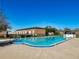 Sparkling community pool with surrounding brick building and fence at 5325 Curry Ford Rd # 101, Orlando, FL 32812