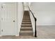 Modern staircase with carpeted steps and dark wood railing at 611 Marsh Reed Dr, Winter Garden, FL 34787