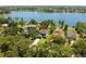 Picturesque aerial shot of a modern home nestled among trees with a beautiful lake backdrop at 6564 Lagoon St, Windermere, FL 34786