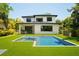 A gorgeous backyard features a pool, lush green lawn and showcases the home's architecture, perfect for outdoor enjoyment at 6564 Lagoon St, Windermere, FL 34786