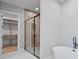 Elegant bathroom featuring a glass-enclosed shower, a soaking tub, and a walk-in closet at 6564 Lagoon St, Windermere, FL 34786