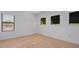 Empty bedroom with hardwood floors, three windows, and white trim at 6564 Lagoon St, Windermere, FL 34786