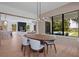 Stylish dining room with an oval table, modern light fixture, and large windows overlooking the landscaped backyard at 6564 Lagoon St, Windermere, FL 34786