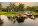 Stunning sunset aerial view of the property featuring a private dock, boat lift, and serene waterfront living at 6564 Lagoon St, Windermere, FL 34786