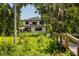 Exterior of the modern home with a view of lush backyard, waterfront, and private walkway at 6564 Lagoon St, Windermere, FL 34786