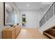 Welcoming foyer with modern decor, light wood floors, and staircase with black railings at 6564 Lagoon St, Windermere, FL 34786