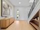 Bright foyer with wood floors, modern artwork, sleek console, and staircase with decorative iron railing at 6564 Lagoon St, Windermere, FL 34786