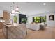 Open concept kitchen with marble island and view into the adjacent light-filled living space at 6564 Lagoon St, Windermere, FL 34786