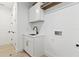 Bright laundry room with white shaker cabinets and a utility sink at 6564 Lagoon St, Windermere, FL 34786