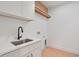 Bright laundry room with a stainless steel sink and storage space at 6564 Lagoon St, Windermere, FL 34786