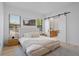 Serene main bedroom with neutral tones, large windows, and convenient access to the en-suite bathroom through sliding door at 6564 Lagoon St, Windermere, FL 34786