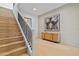 Staircase featuring a black metal banister, hardwood stairs, and modern artwork enhancing the home's interior at 6564 Lagoon St, Windermere, FL 34786