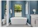 A modern bathroom features a freestanding tub beneath a window with views of lush greenery at 809 Maxwell St, Orlando, FL 32804