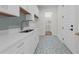 Well-lit laundry room featuring stylish patterned flooring, white cabinetry, and modern fixtures at 809 Maxwell St, Orlando, FL 32804