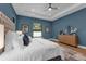 Comfortable main bedroom features a tray ceiling, large bed, and windows, creating a peaceful and inviting atmosphere at 809 Maxwell St, Orlando, FL 32804