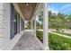 View of the house's porch with a blue double door, wooden ceiling and white walls, and landscaped shrubs at 809 Maxwell St, Orlando, FL 32804