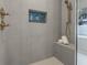 The stylish shower is tiled with sleek grey and features a built-in seat and a blue mosaic niche at 809 Maxwell St, Orlando, FL 32804