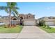 Two-story house with a large driveway, landscaping, and palm trees at 8118 Yellow Crane Dr, Kissimmee, FL 34747