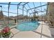 Enclosed pool and spa with lounge chairs and a hanging chair at 8118 Yellow Crane Dr, Kissimmee, FL 34747