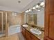 Elegant bathroom with double vanity, granite countertop, and a soaking tub at 914 Charo Pkwy # 112, Davenport, FL 33897