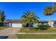 Single-story home with a white garage door and palm trees in the front yard at 1354 Tierra Cir, Winter Park, FL 32792