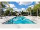 Community pool with palm trees and lounge chairs at 1368 Centre Court Ridge Dr # 104, Reunion, FL 34747