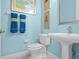 Simple, clean powder room with pedestal sink and updated toilet at 14442 Avenue Of The Rushes, Winter Garden, FL 34787