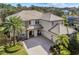 Two-story house with tile roof, stone accents, and palm trees in the front yard at 14442 Avenue Of The Rushes, Winter Garden, FL 34787