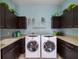 Well-equipped laundry room, featuring washer, dryer, and ample cabinetry at 14442 Avenue Of The Rushes, Winter Garden, FL 34787