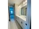 Bright bathroom featuring double sinks, white cabinetry, and contemporary lighting fixtures at 16337 Silver Grove Blvd, Winter Garden, FL 34787