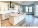 Open kitchen with island, white cabinets, and wood-look floors at 16337 Silver Grove Blvd, Winter Garden, FL 34787