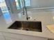 Close-up of a stainless steel kitchen sink installed in a white countertop with a modern faucet at 16337 Silver Grove Blvd, Winter Garden, FL 34787
