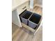 Innovative kitchen storage with a pull-out drawer cleverly concealing trash bins, optimizing space and functionality at 16337 Silver Grove Blvd, Winter Garden, FL 34787