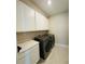 Modern laundry room with cabinetry and stainless steel washer and dryer at 16337 Silver Grove Blvd, Winter Garden, FL 34787