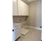 Spacious laundry room with tile floors, white cabinets, and utility connections at 16337 Silver Grove Blvd, Winter Garden, FL 34787