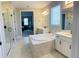 Luxurious main bathroom with a standalone tub, dual vanities, and a glass-enclosed shower, offering a spa-like experience at 16337 Silver Grove Blvd, Winter Garden, FL 34787